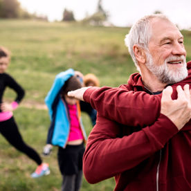 Groep volwassenen die buiten samen sporten. 