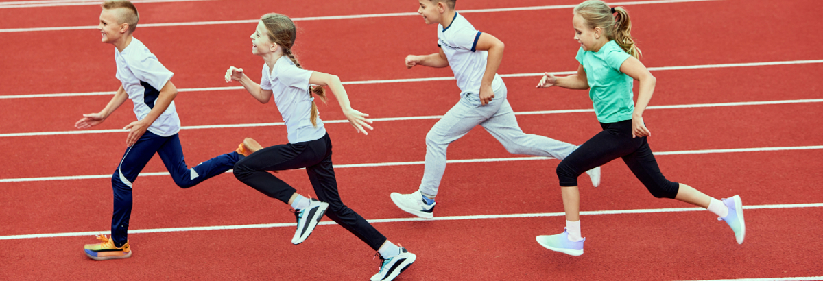 Kinderen die over een atletiekbaan rennen. 