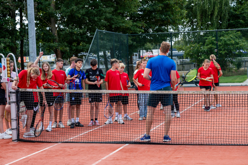 Leerlingen die samen sporten op de tennisbaan in Echt